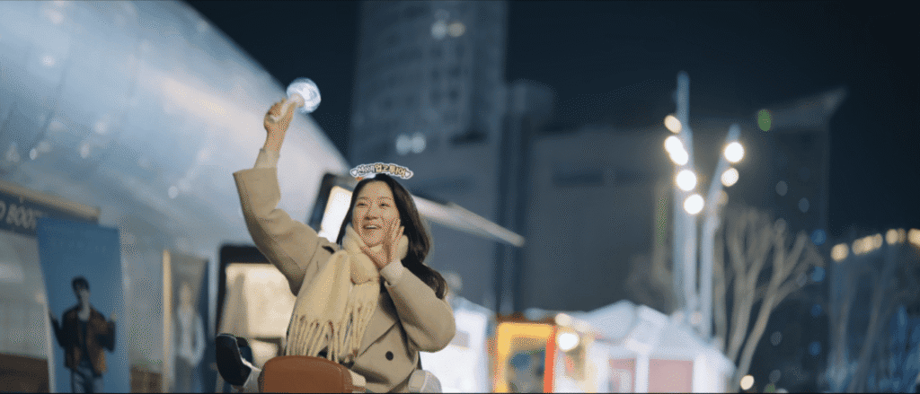 K-drama character at Dongdaemun plaza holding light at night
